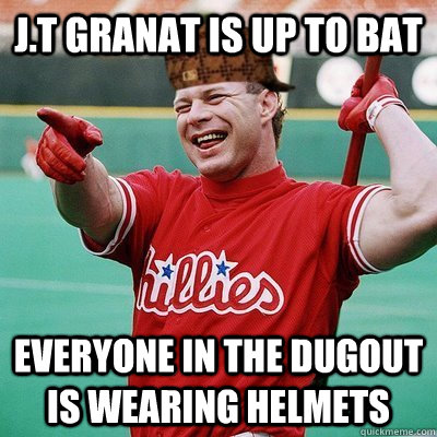 J.t granat is up to bat everyone in the dugout is wearing helmets  