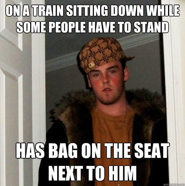 On a train sitting down while some people have to stand Has bag on the seat next to him  Scumbag Steve