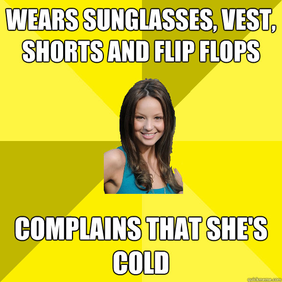 wears sunglasses, vest, shorts and flip flops complains that she's cold  