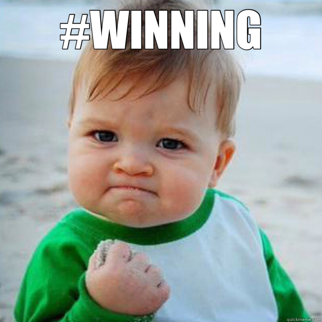 Picture of baby with hand in fist and hashtag that says "winning" over it