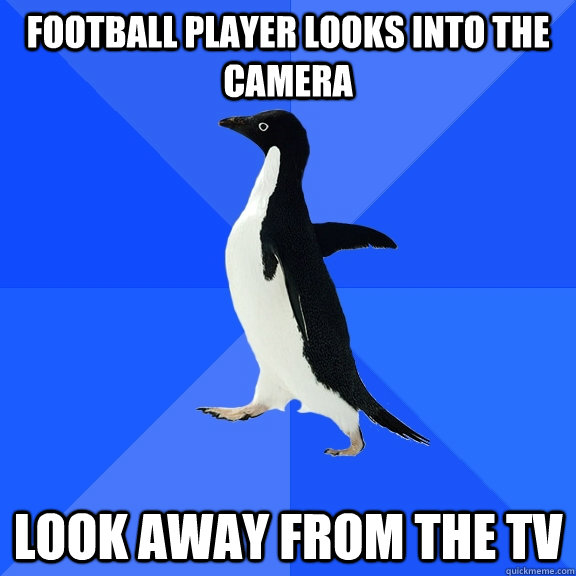 Football player looks into the camera look away from the Tv  Socially Awkward Penguin