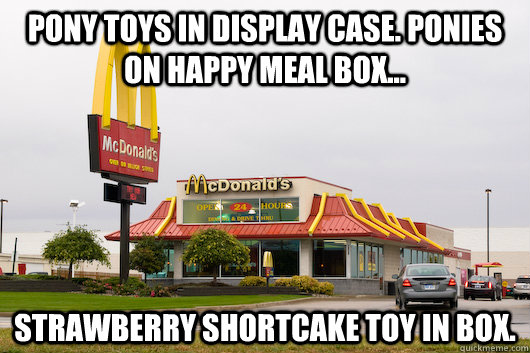 pony toys in display case. ponies on happy meal box... strawberry shortcake toy in box.  