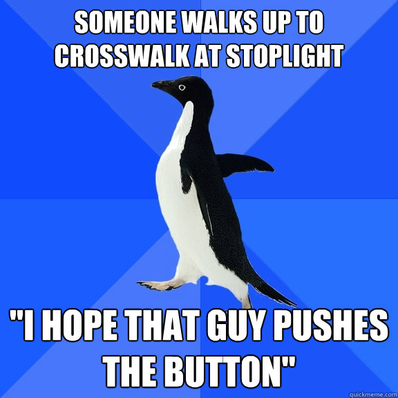 SOMEONE WALKS UP TO CROSSWALK AT STOPLIGHT 