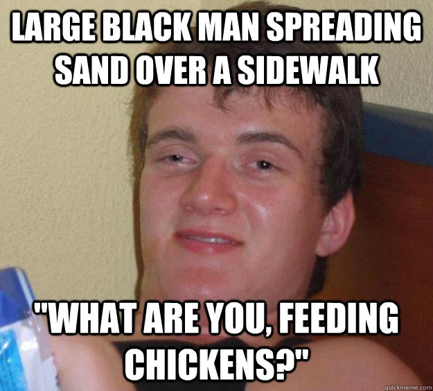 large black man spreading sand over a sidewalk 