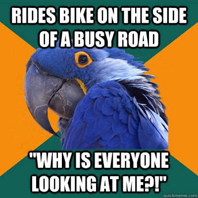 Rides bike on the side of a busy road 